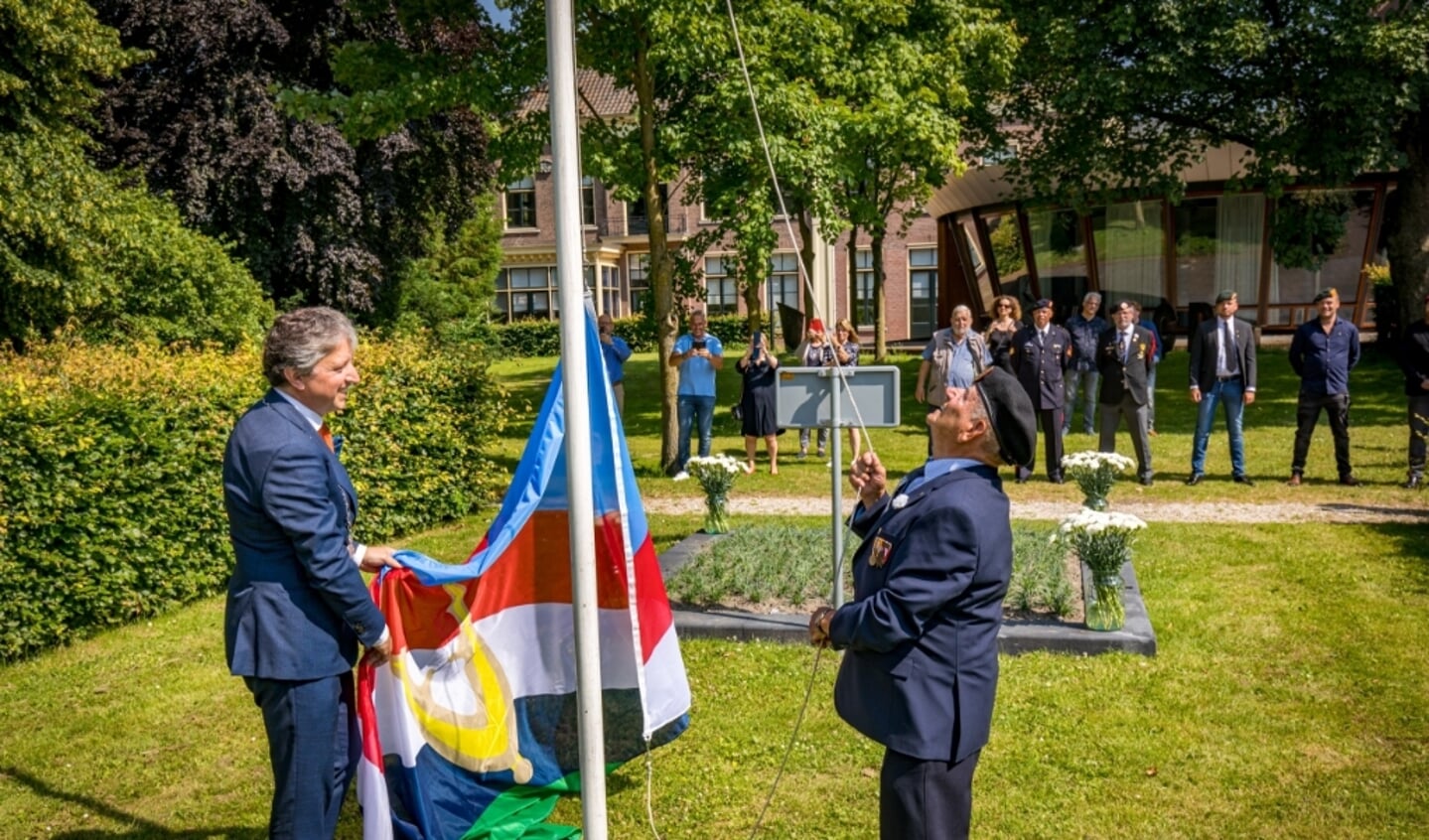 Burgemeester Hans Beenakker en oudste veteraan M. van Gelder onthulde met het hijsen van een nieuwe vlag het witte anjerperk in stadstuin op Nationale Veteranendag 2021 Foto Jan Bouwhuis.