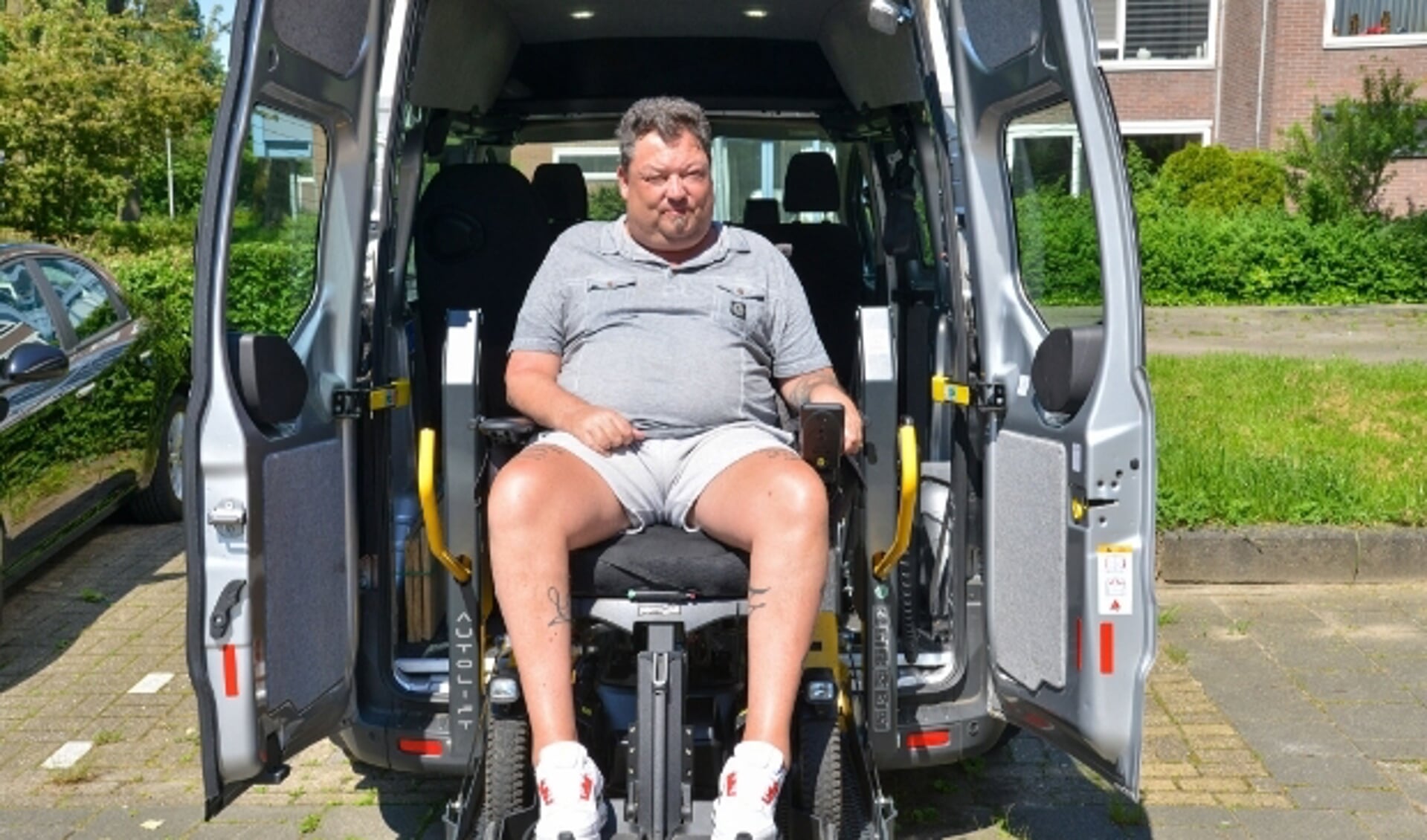 Karo Murk bij de rolstoelbus van ALS Op De Weg, die hij moet inleveren omdat zijn ziekte niet progressief genoeg is. Foto: Paul van den Dungen