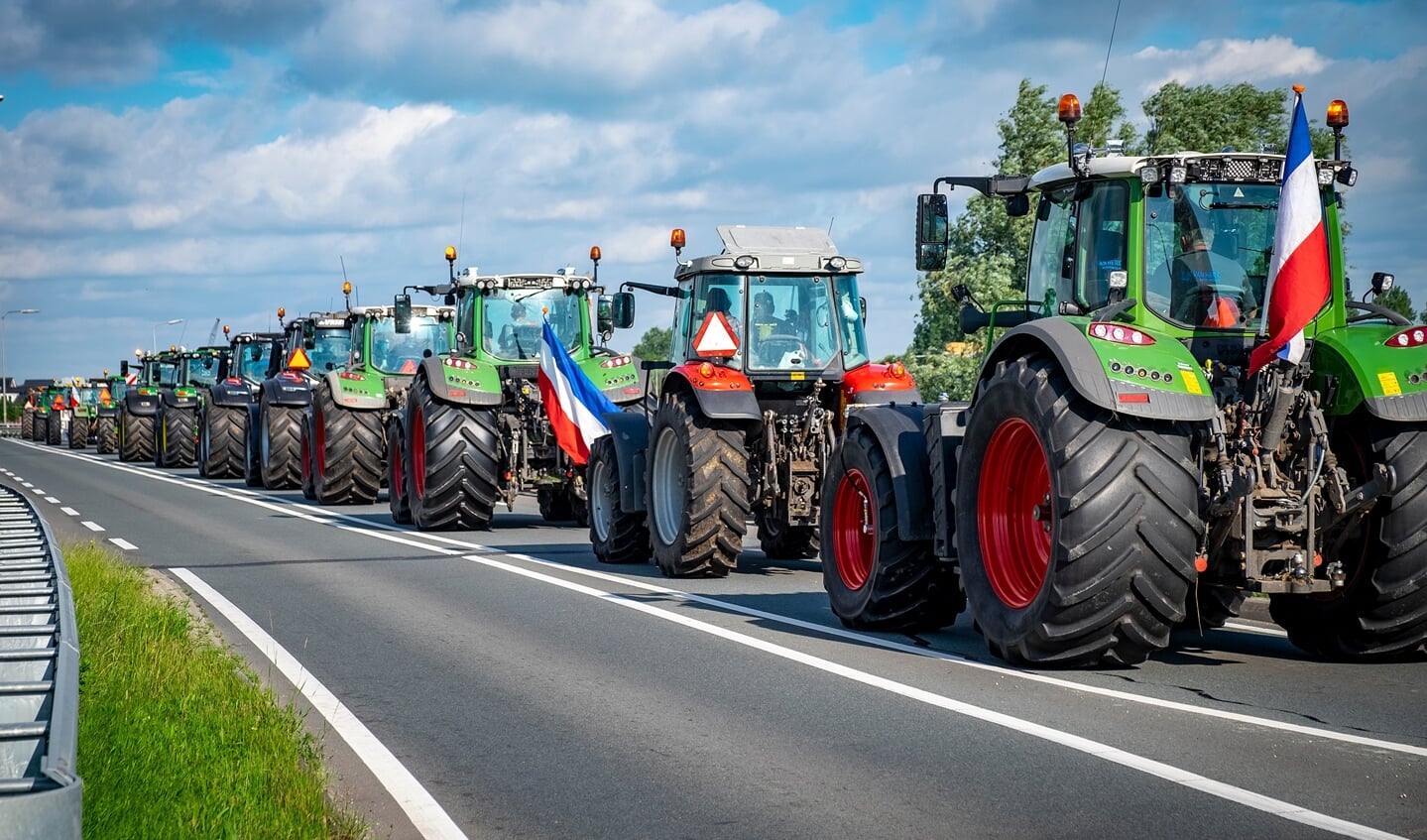 • Een rij tractoren op de N210.