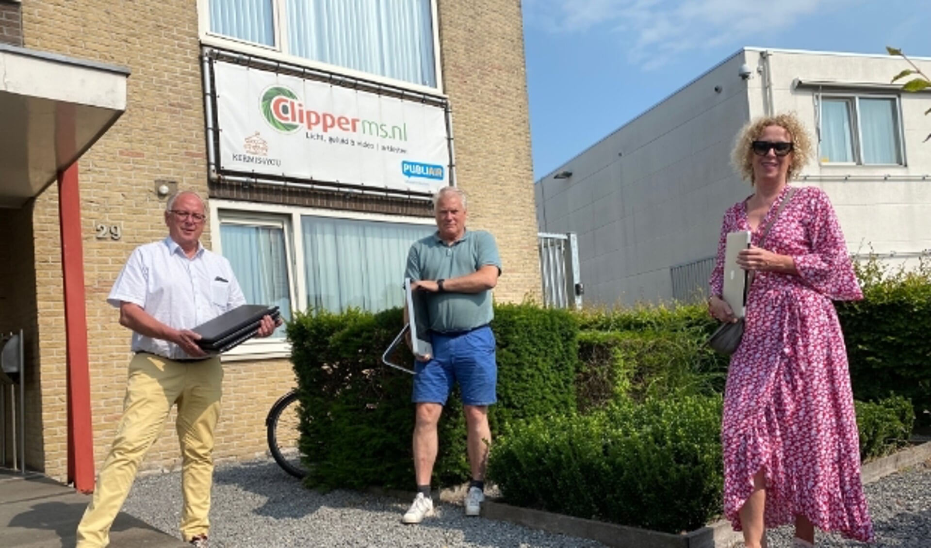 Bestuursleden Ton Kwakkernaat en Carolien Gerritsen van Stichting Leergeld Het Groene Hart nemen laptops in ontvangst bi René den Daas.