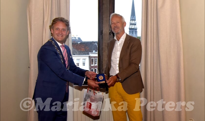 <p>Robert Kreder krijgt de vrijwilligerspenning uitgereikt door bgm Pieter Verhoeve</p>