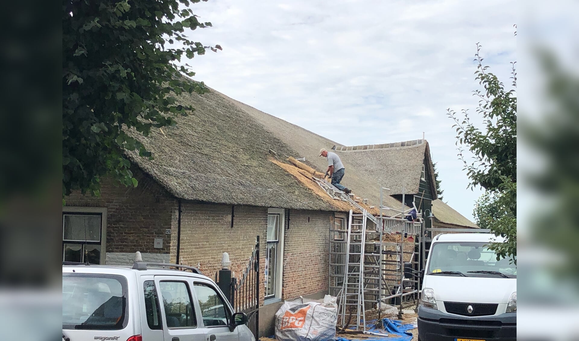 • De reparaties aan het rieten dak zijn in volle gang.