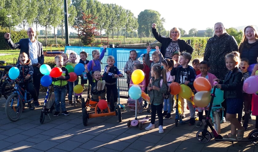 Wethouder Hans Tanis met de jongste kinderen van de Prins Willem Alexanderschool en kinderdagverblijf De Schat in Eethen.