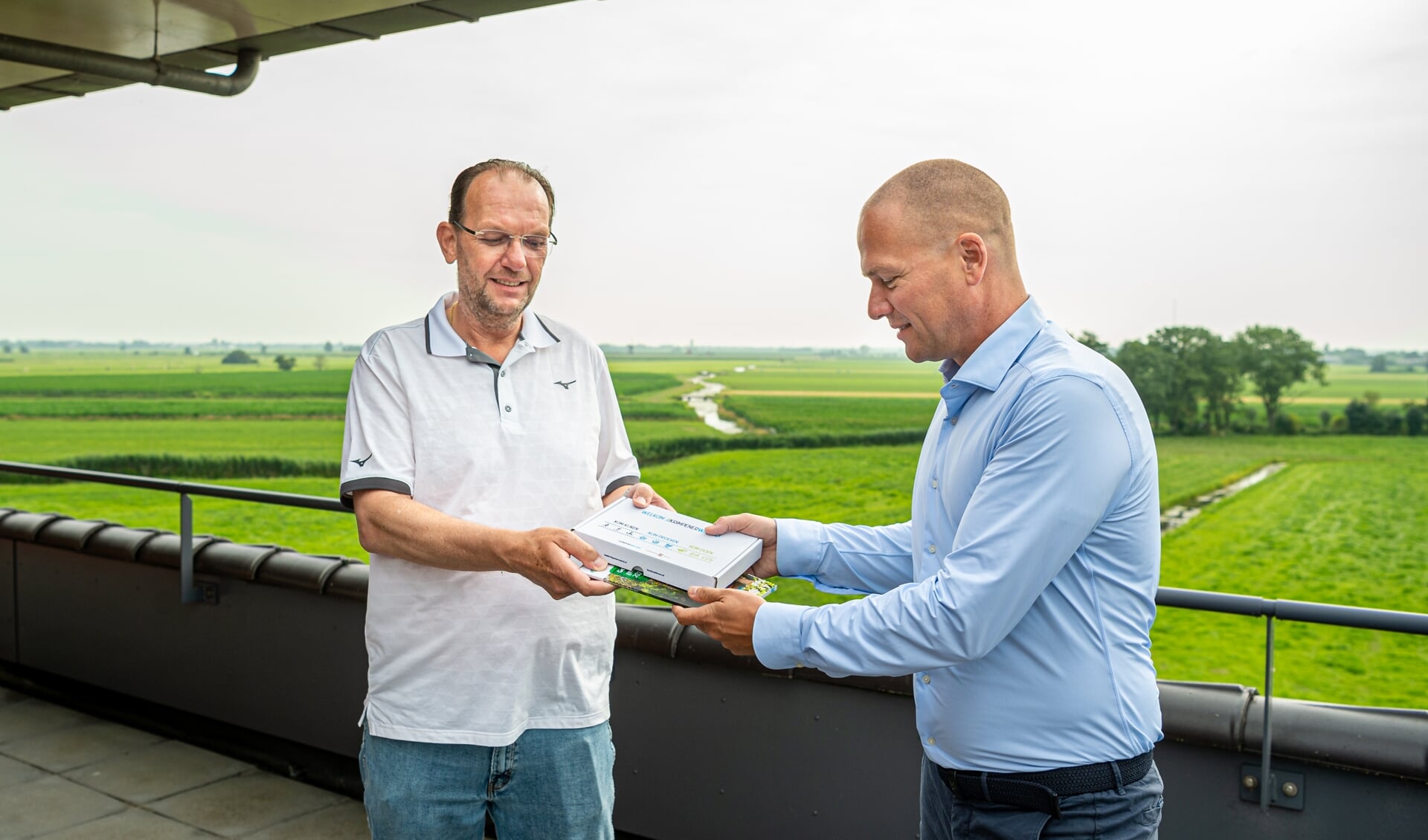 • Namens Stichting Promotie Krimpenerwaard en Zilverstad Marketing overhandigt Stefan van Beeten de nieuwe Welkomstbox aan Wilfred Rottier.