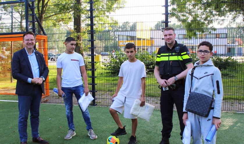 <p>Drie van de vier jonge helden met burgemeester en politie.</p>