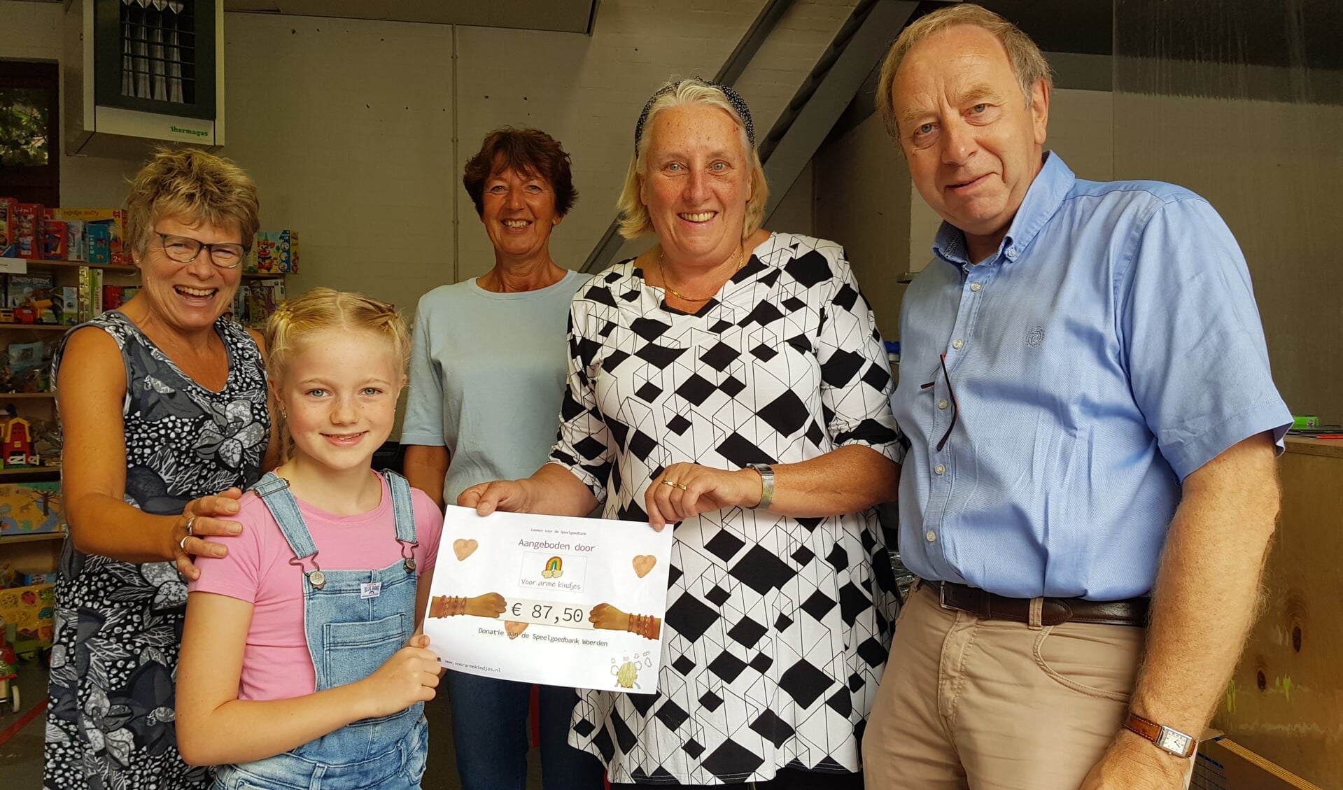 • June ging zaterdag langs bij de speelgoedbank in Woerden om een zelfgemaakte cheque te overhandigen.