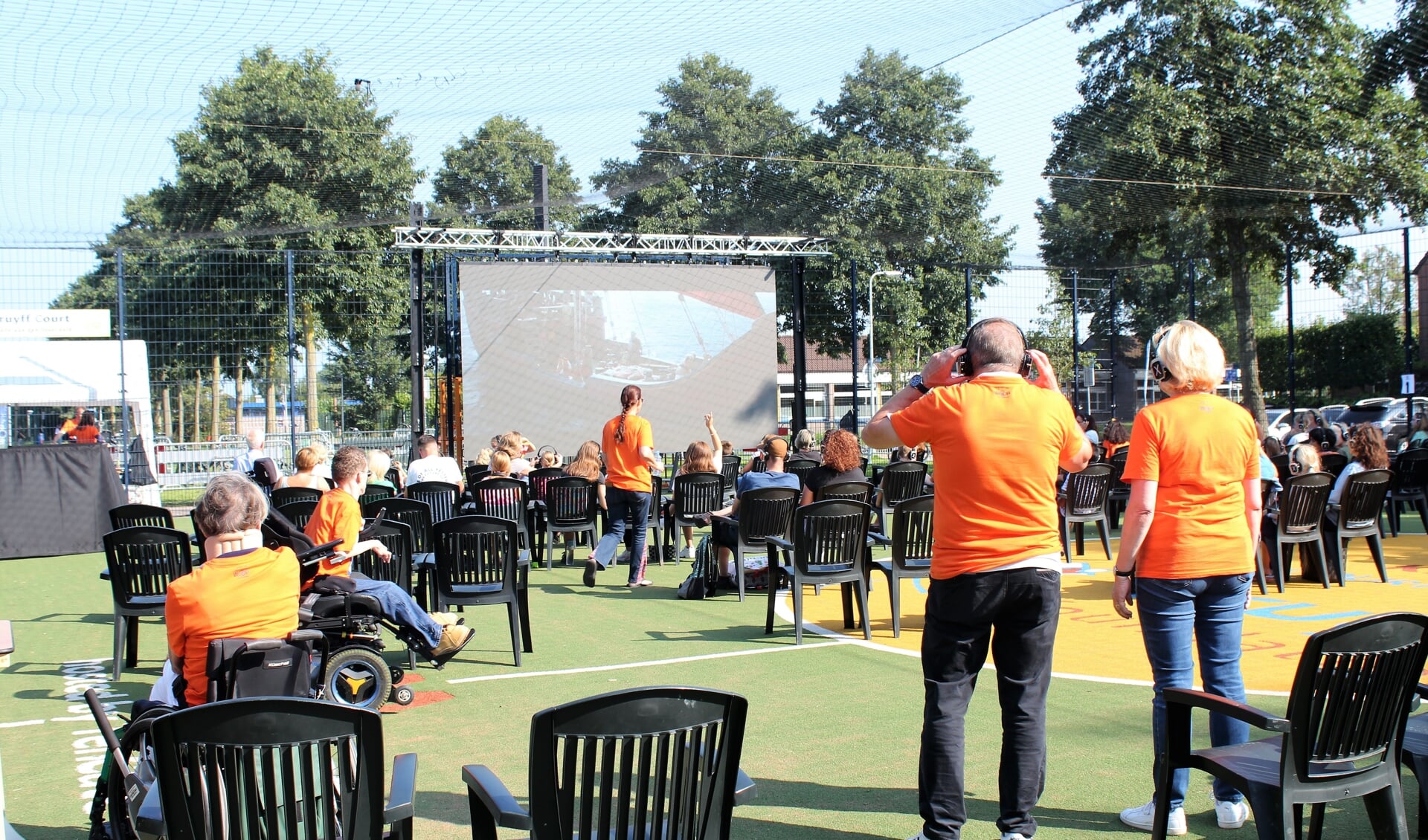 • Bezoekers voor het grote scherm van de openluchtbioscoop.