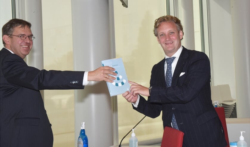<p>Peter van den Berg overhandigt het eerste exemplaar.aan Pieter Verhoeve</p>