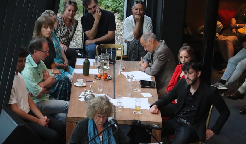 <p>• Een uitvoerende muzikant met op de achtergrond de deelnemende artiesten op deze eerste jamsessie.</p>