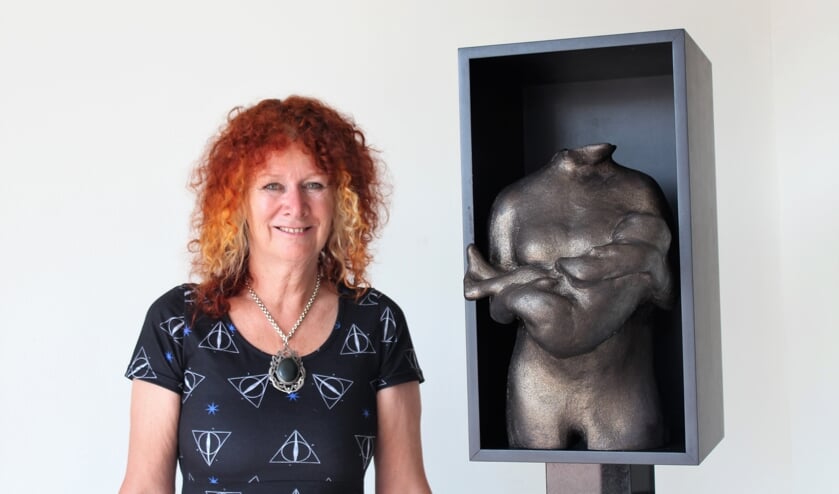 Carrie Jansen voor het beeld van een moeder met kind.