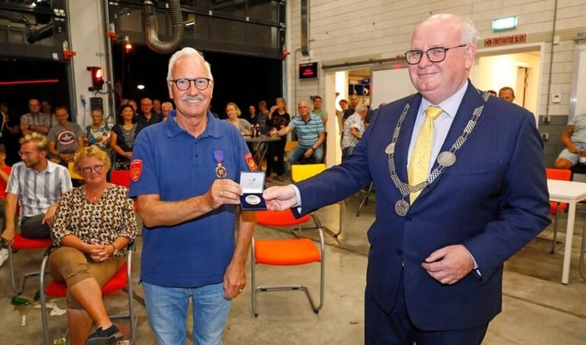 Brandweerman Gerard Koekman ontvangt de Erepenning van burgemeester Frans Backhuijs.