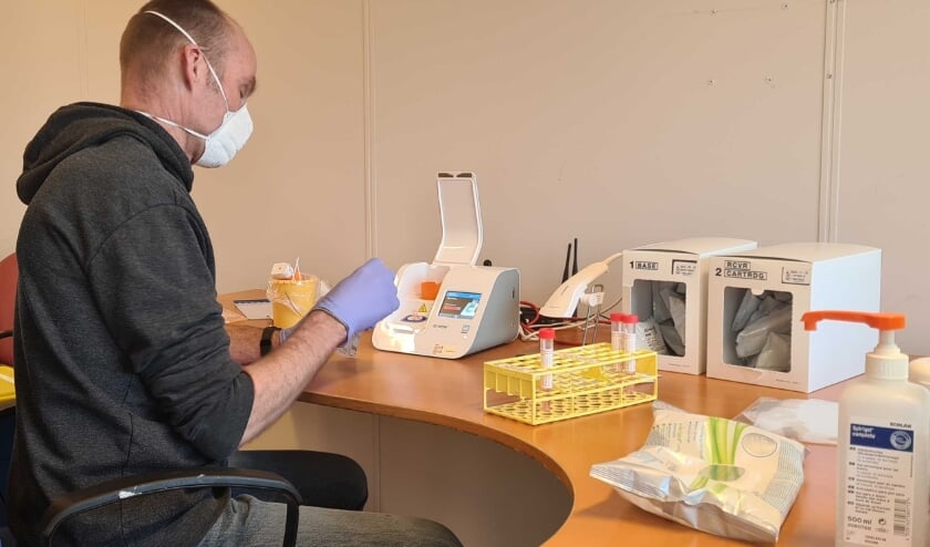 <p>Een medewerker van het Gemiva-testteam analyseert afgenomen coronatesten. </p>