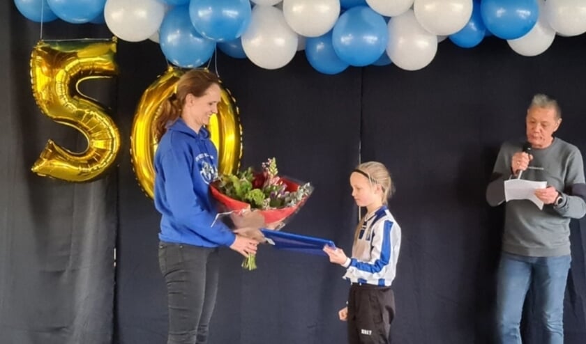 <p>De vrijwilligersprijs werd aan Anouk (links) uitgereikt door voorzitter Frans Schults en zijn dochter Fenne.</p>