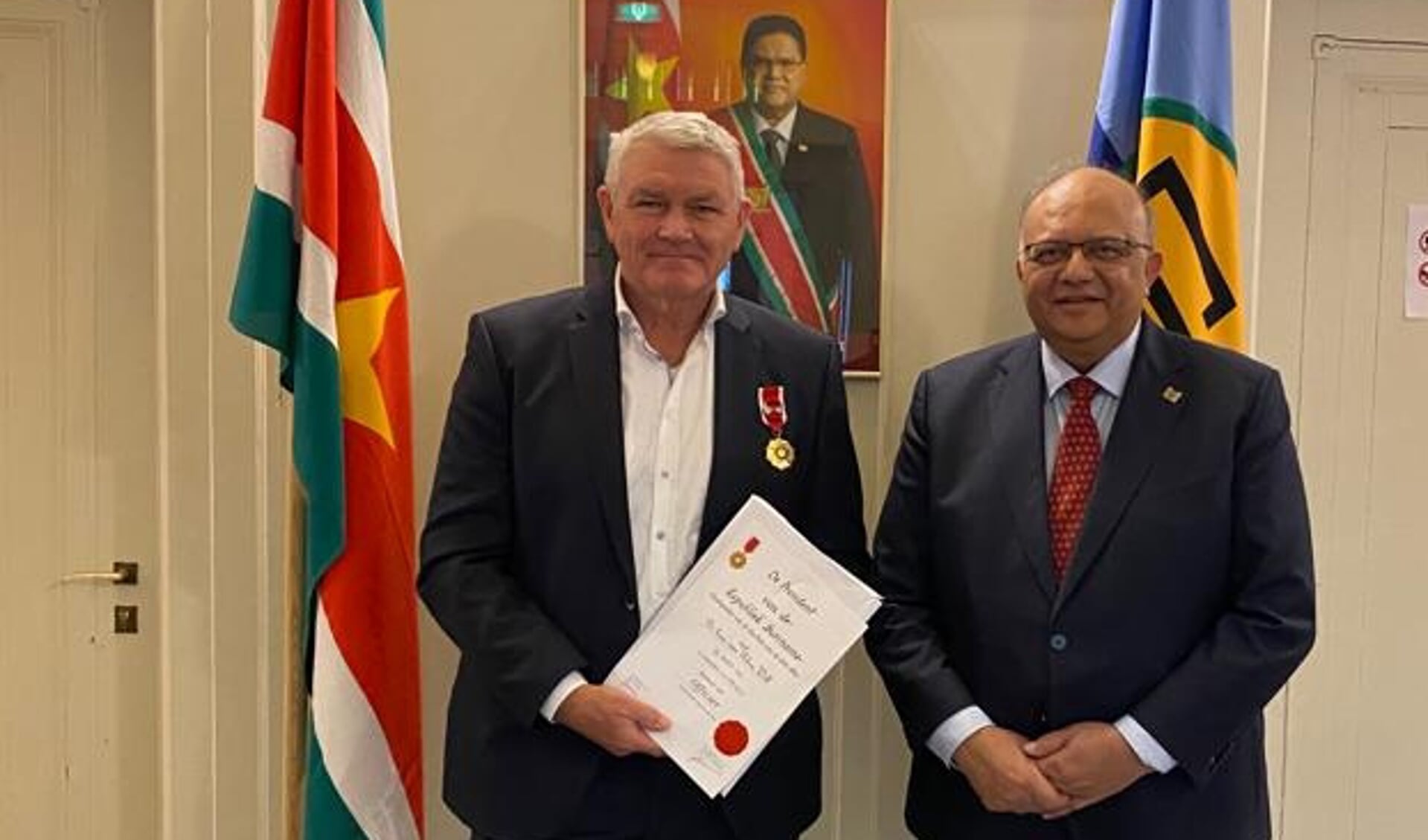 Will van Rhee ontving de oorkonde en de onderscheiding uit handen van de ambassadeur van Suriname, mr. Rajendre Khargi.