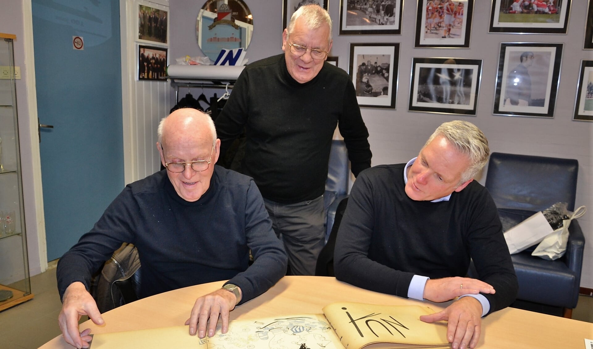 • Teunis en John Klok kijken samen met voorzitter John Boekelman in het naslagwerkje dat ter gelegenheid van het kampioenschap in 1967 is gemaakt.