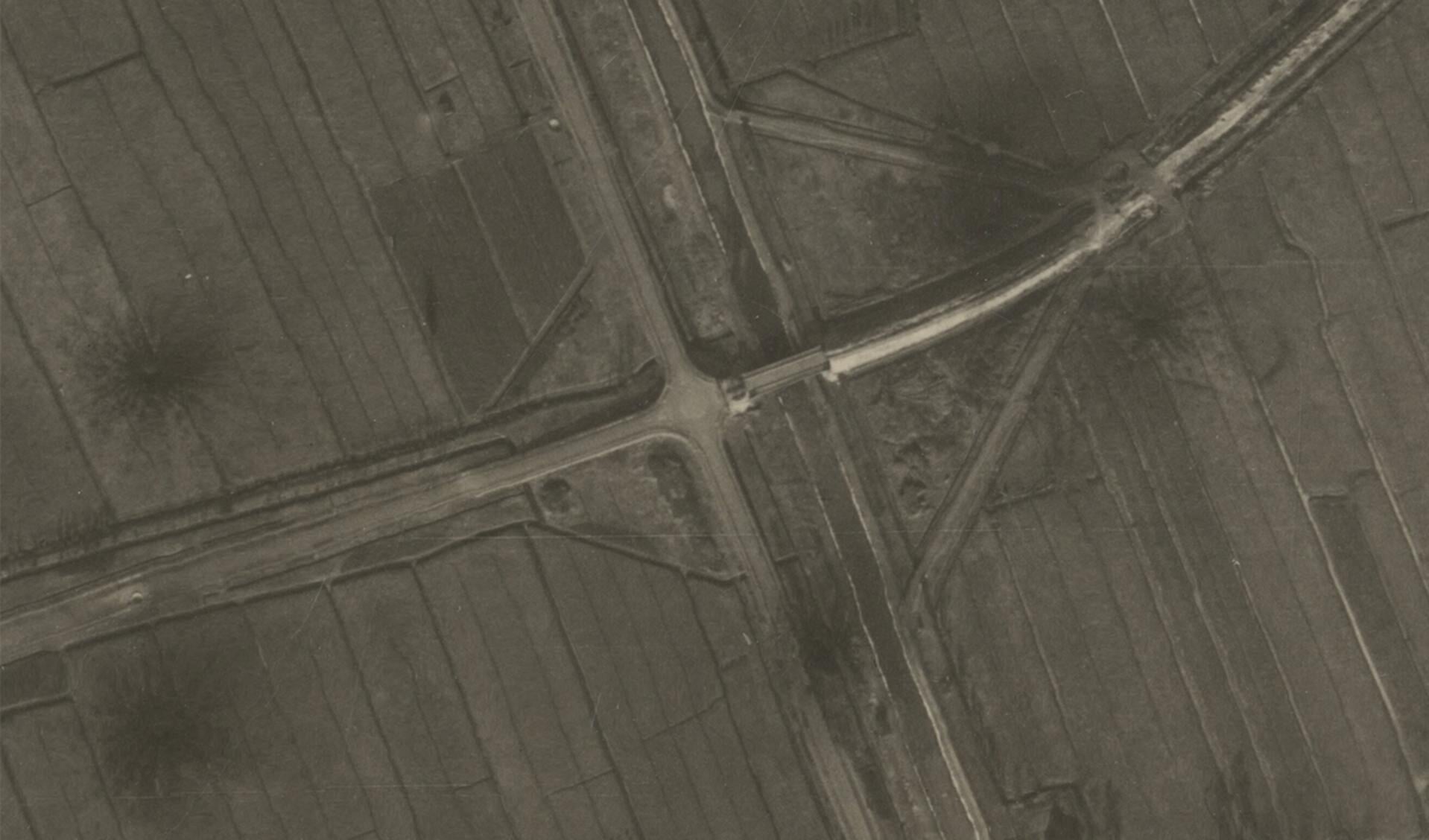 • Het kruispunt in 1945, met duidelijk zichtbaar de kraters van de bominslagen.