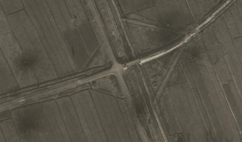 • Het kruispunt in 1945, met duidelijk zichtbaar de kraters van de bominslagen.