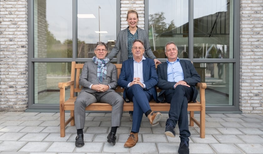 • Gerard van Brakel, Harry Vogelaar en Arpad Backx (v.l.n.r.) nemen plaats op de tuinbank die geschonken is door BM van Houwelingen. Staand: Lotte van Houwelingen. 