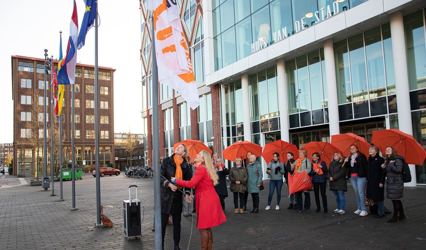 Wethouder Anna van Popering hijst  de Orange the World vlag voor het Huis voor de stad
