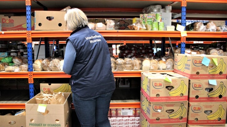 • Vrijwilliger van Voedselbank Woerden bezig met het sorteren van producten.