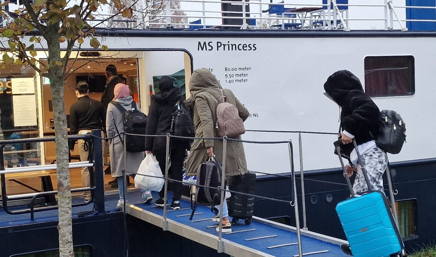 Vluchtelingen betreden het opvangschip in Nieuwegein.