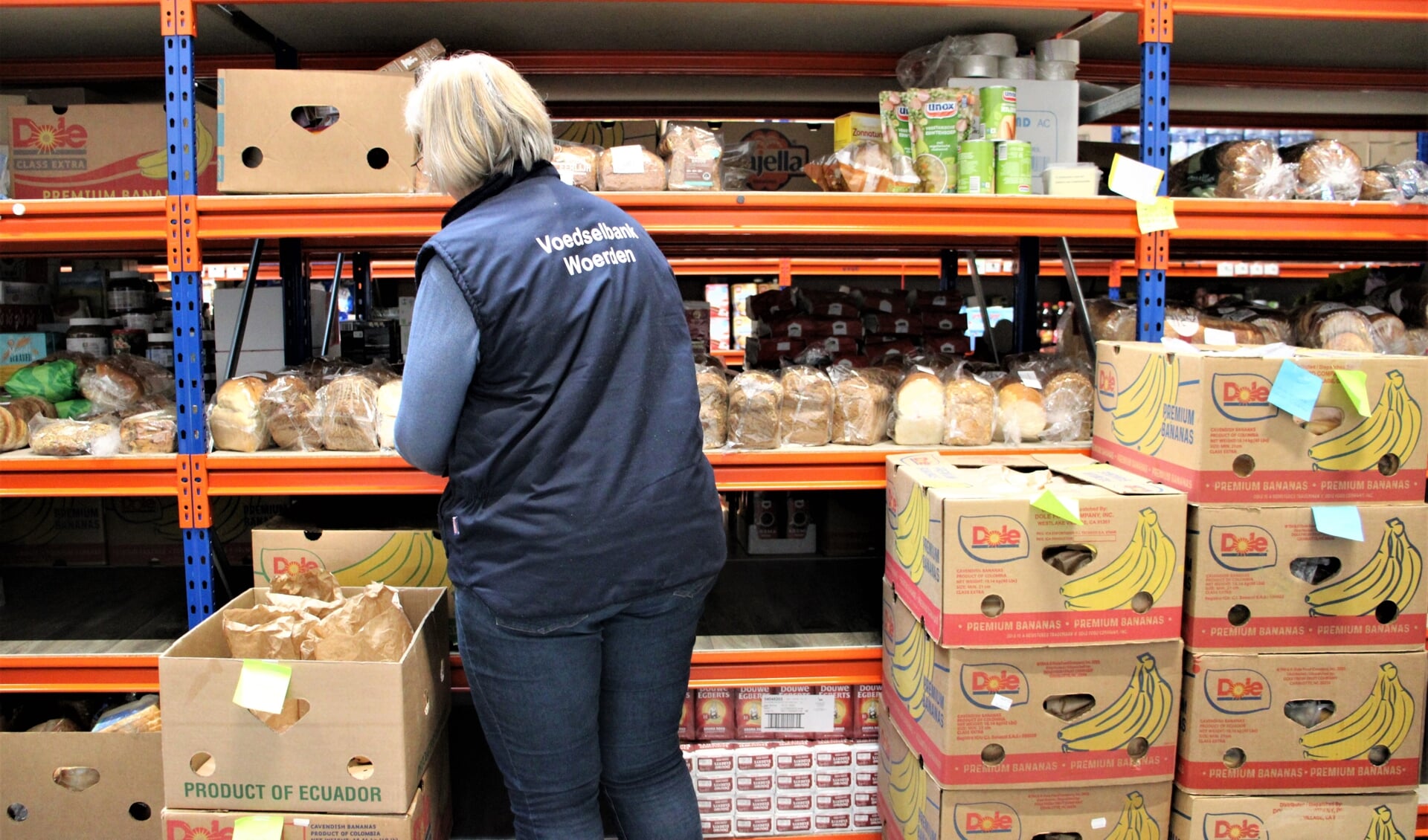 • Vrijwilliger van Voedselbank Woerden bezig met het aanvullen van de schappen. 