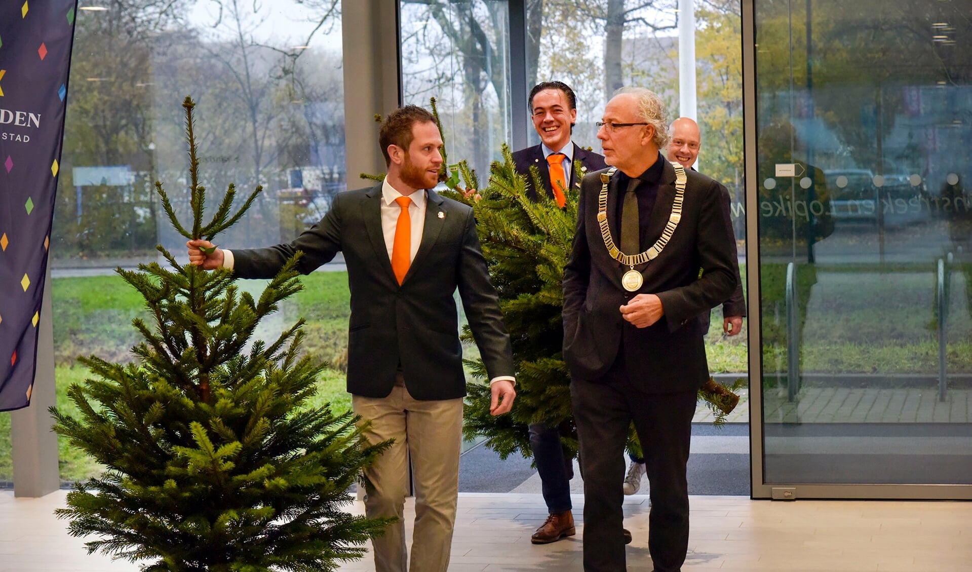 Leden van Tafelronde 185 komen samen met burgemeester Victor Molkenboer het gemeentehuis binnen voor de overhandiging van de eerste kerstbomen. 