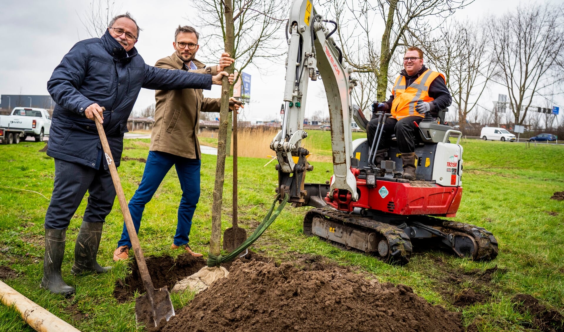 • Wethouder Arjan Kraijo en heemraad Mathieu Gremmen van Waterschap Rivierenland planten een boom bij carpoolplaats De Kabelbaan.