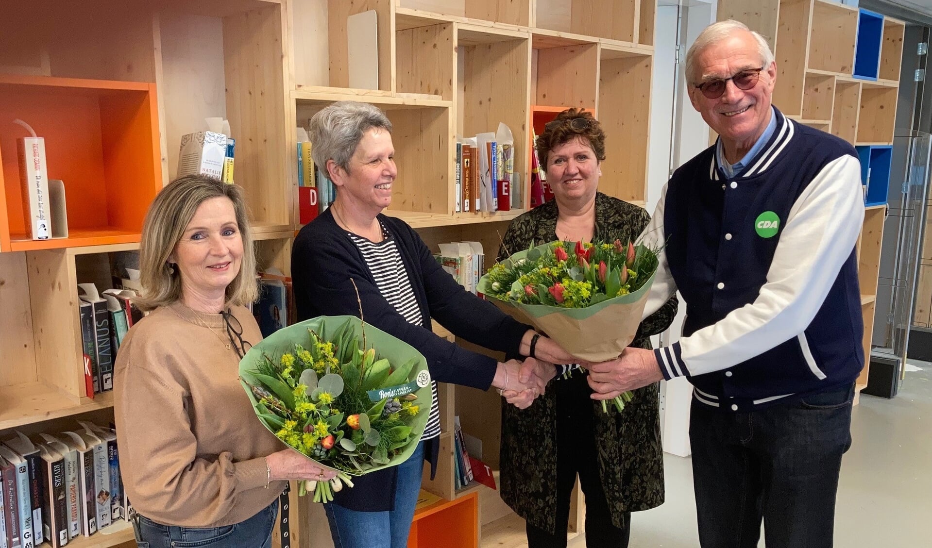 • Jan Mulder van CDA Papendrecht overhandigt bloemetjes aan de medewerkers van de bibliotheek.