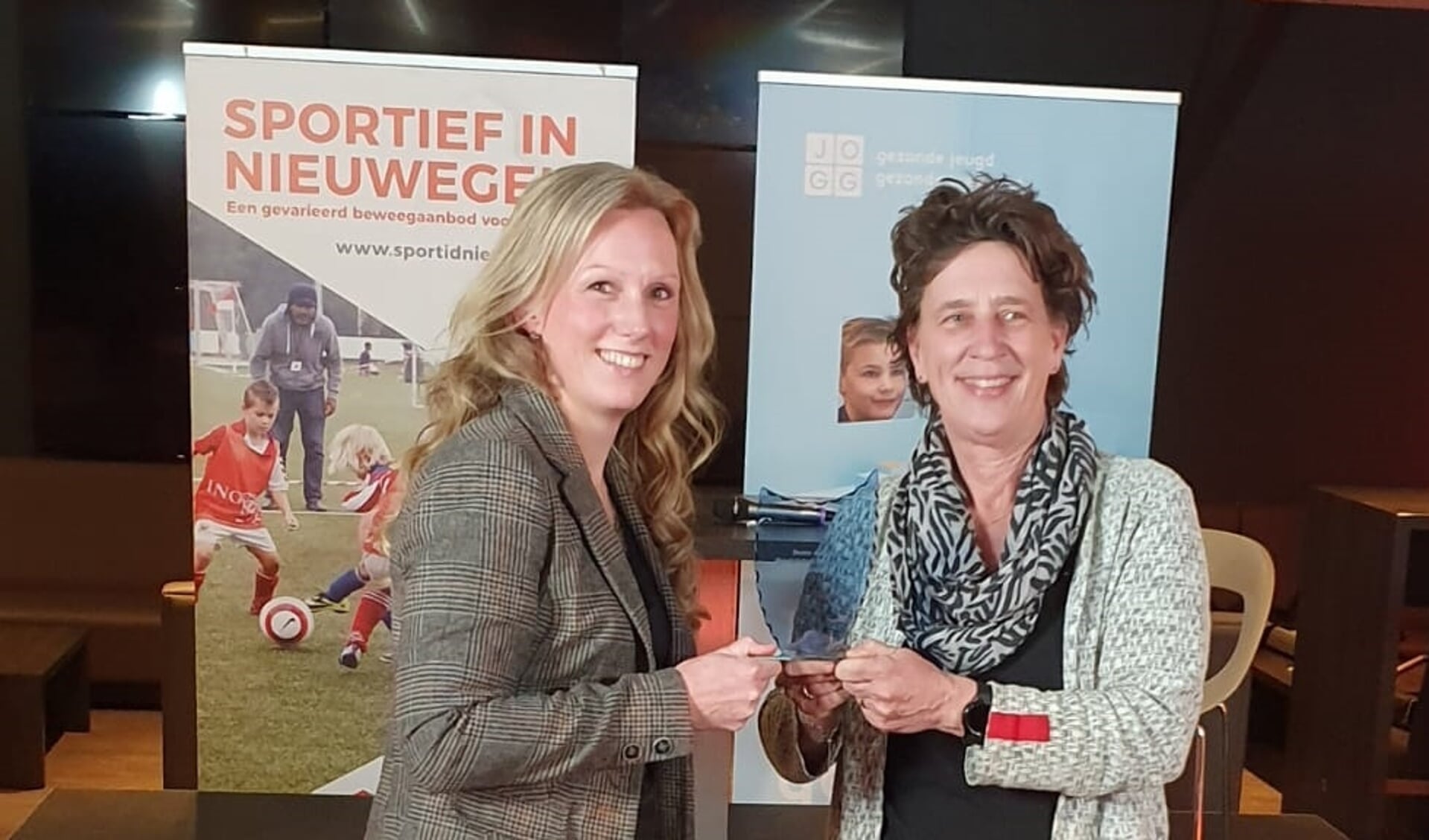 Heleen Peters van Lokale Vernieuwing (links) neemt de prijs voor 'beste debater' in ontvangst van juryvoorzitter Anneke van Zanen (rechts).