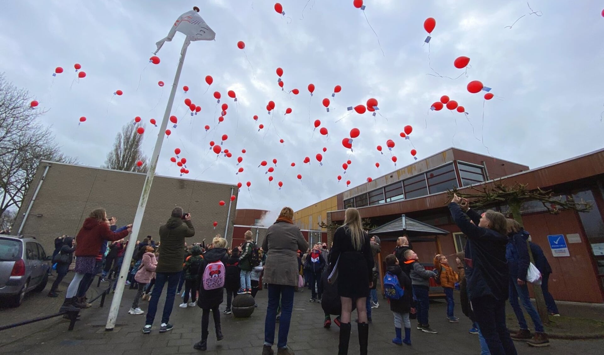 Met het loslaten van ballonnen lieten de leerlingen symbolisch hun vertrouwde schoolgebouw los.