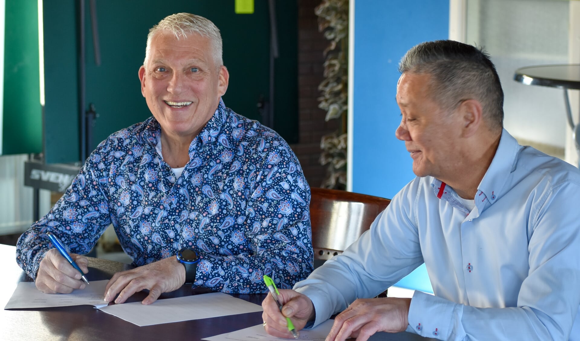 Trainer Arie Koning (links) zet zijn handtekening onder het contract. Rechts op de foto voorzitter Frans Schultz.