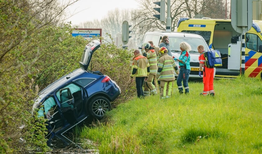 Een auto schoot over de kruising, ramde twee verkeerslichten en eindigde met de neus in de sloot.
