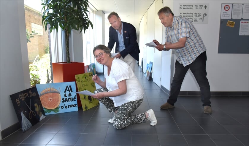 <p>Marianne van der Veer, Hans van Aalst en Jan Roelevink bij de winnende borden.</p>