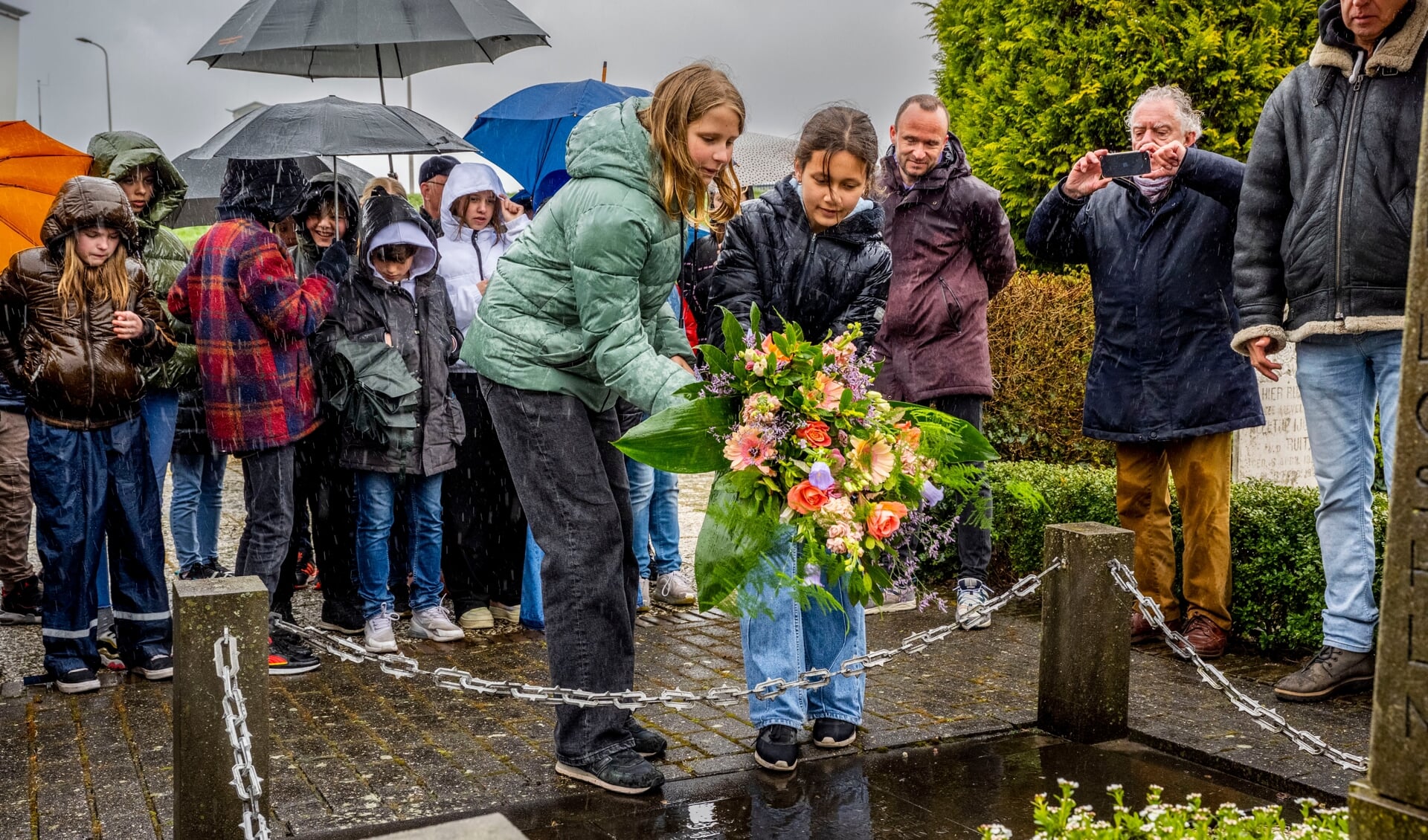 • De leerlingen leggen bloemen neer bij het oorlogsmonument aan de Nijverheidstraat.