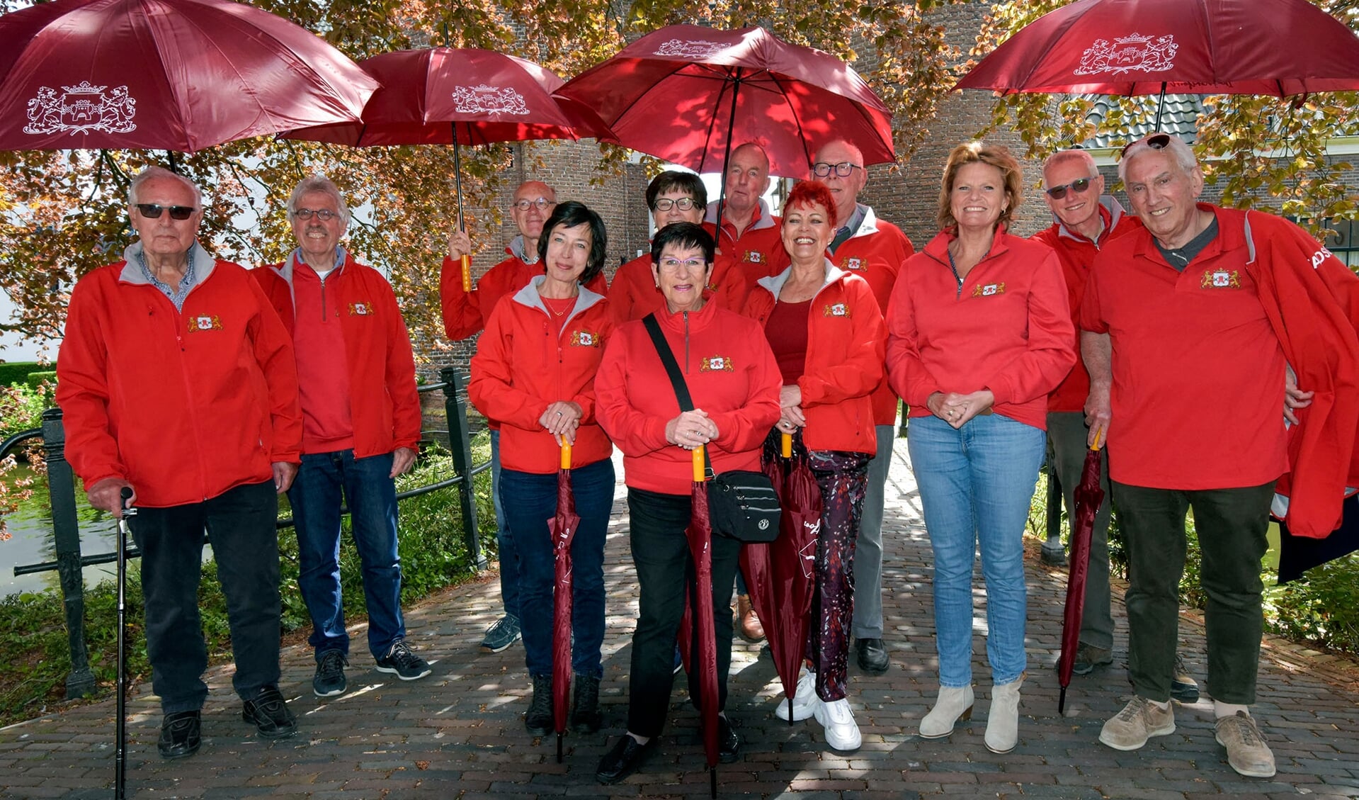 De stadsgidsen van Montfoort in hun opvallend rode outfit met bijbehorende paraplu