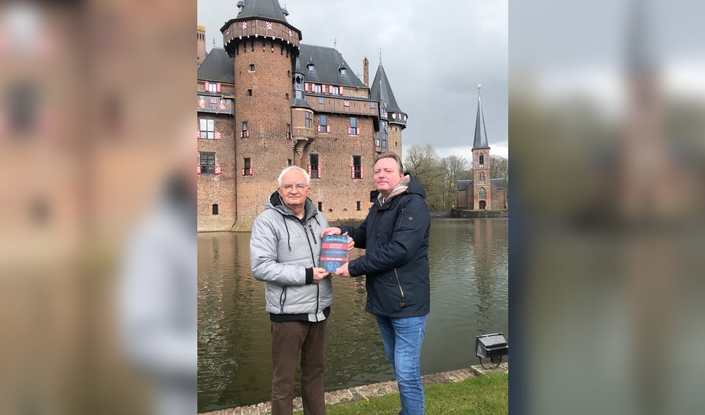 • Piet van Dieren (links) krijgt van zijn uitgever het eerste exemplaar van zijn boek 'Het Meesterplan van de Nieuwe Wereldorde' aangeboden. In twee hoofdstukken van dit deel vormt Kasteel de Haar het decor voor de actie. 
