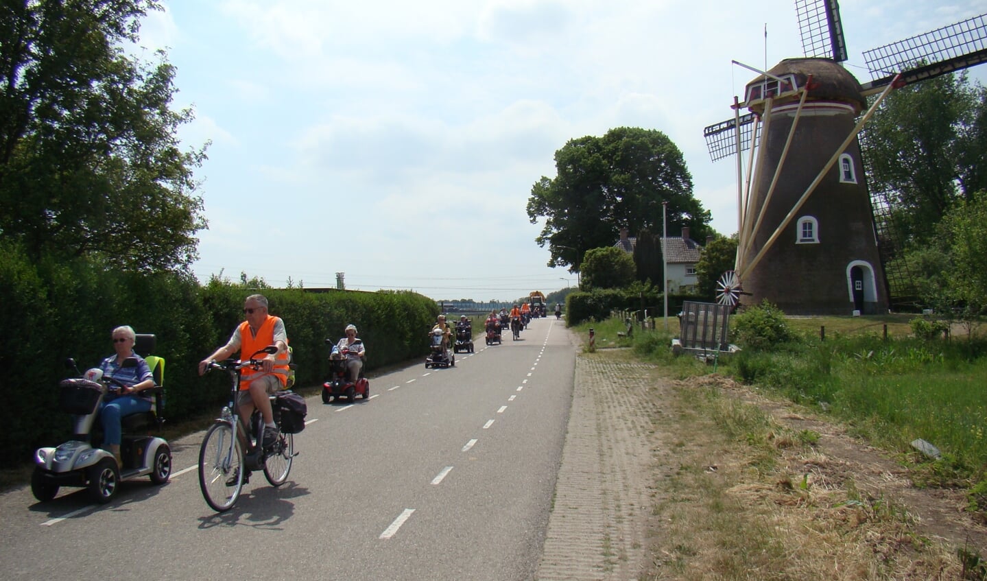 Rijdend langs de Linge passeert het gezelschap de imposante en kleurrijke molen in Zoelen 