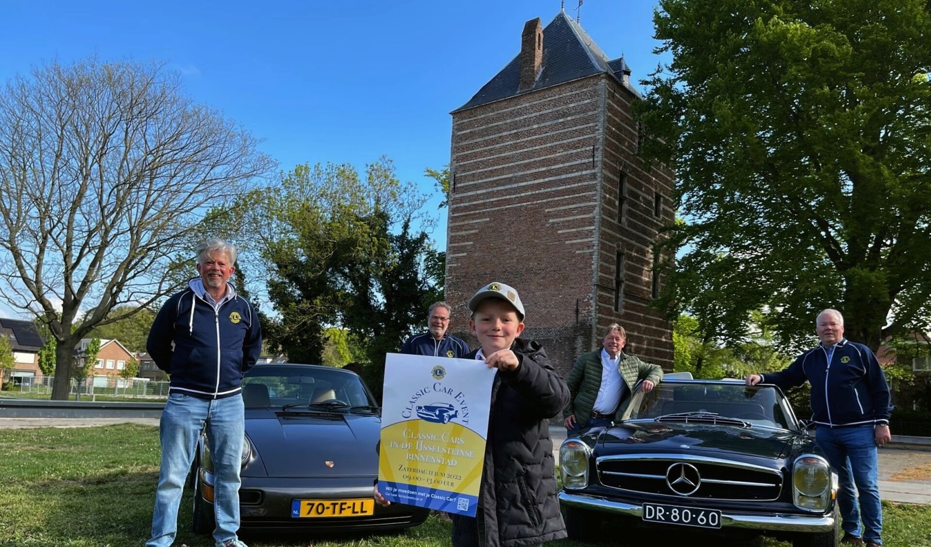'Lionwelp' Sepp toont de poster, zijn vader met collega's twee classic cars die op 11 juni te zien zijn.