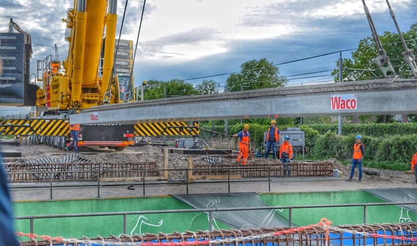<p>• Brugdeel van de fietsbrug wordt naar z'n plek gehesen.</p>
