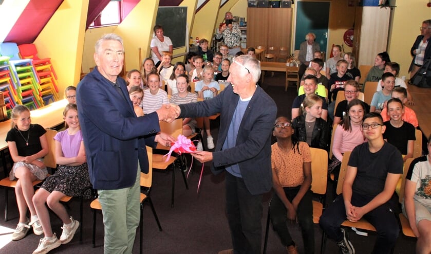 • Wethouder Kees Jongmans (links) overhandigt de eerste gedichtenbundel aan Roel Teeuwen van de Lionsclub Alblasserwaard Souburgh.  