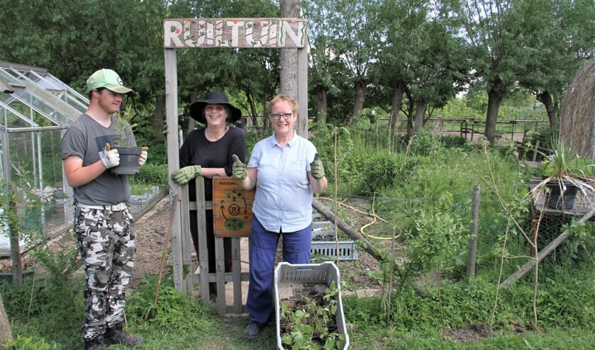 • Ester Korteland (midden) in de ruiltuin, met twee cliënten van de zorgboerderij.