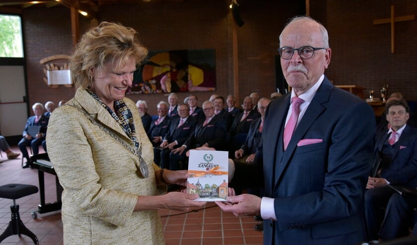 Burgemeester Petra van Hartskamp krijgt het eerste exemplaar van Kroniek van een dorpskoor.  