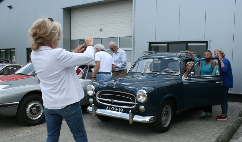 <p>• Deze vrijwilligsters zijn klaar voor de start. Nou ja, nog wel even kijken hóe je deze Peugeot 403 moet starten...</p>
