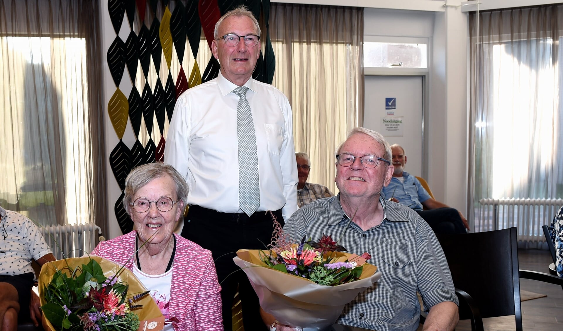 • Jan Kraaiveld met jubilarissen Nel Booi en Jan Stemerding.