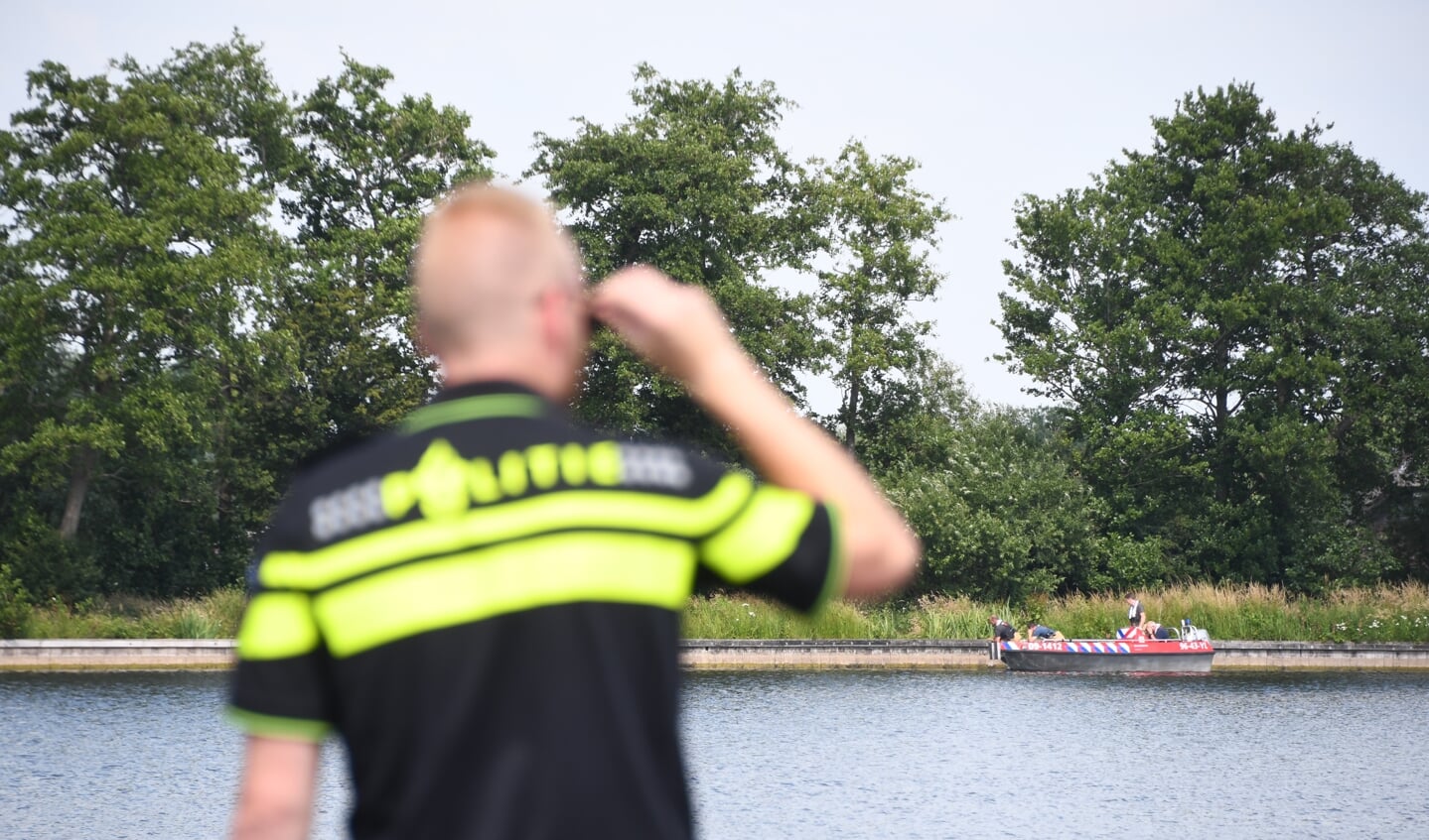 • De brandweer zoekt met een boot in de plas naar de vermiste persoon.