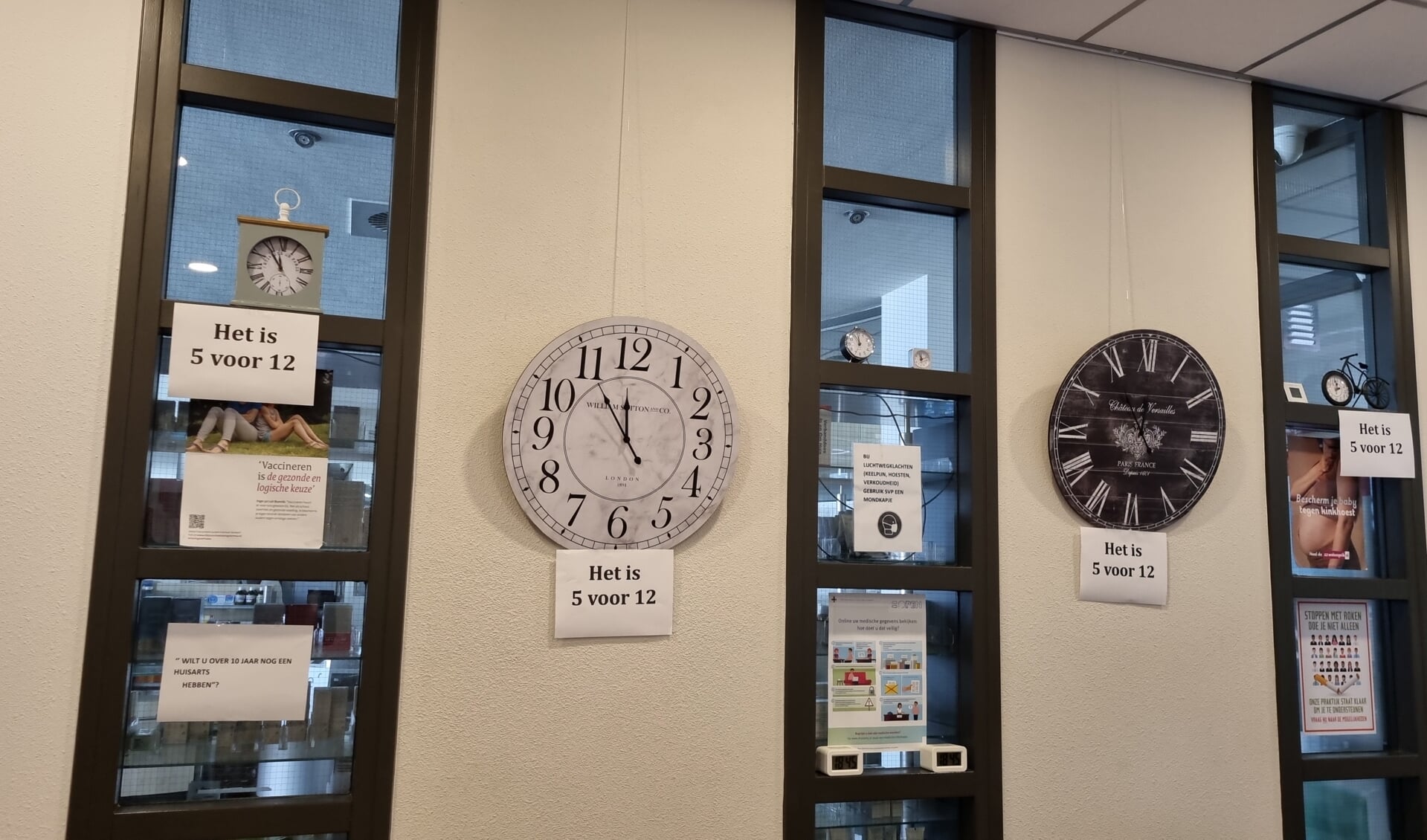 Een aantal van de klokken in de wachtkamer in de praktijk geven de tijd aan: vijf voor twaalf.