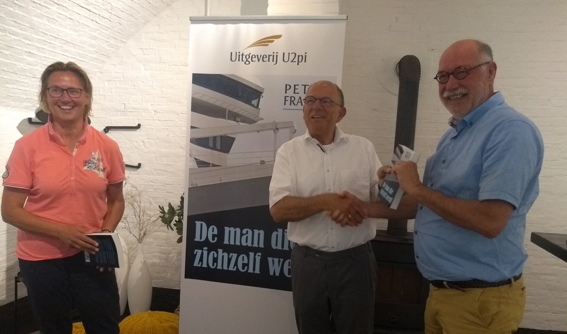 • De schrijver Frans Pieters (midden) overhandigt twee eerste exemplaren aan Frank van Sebille en Cora Metz van tennisvereniging Woudrichem.
