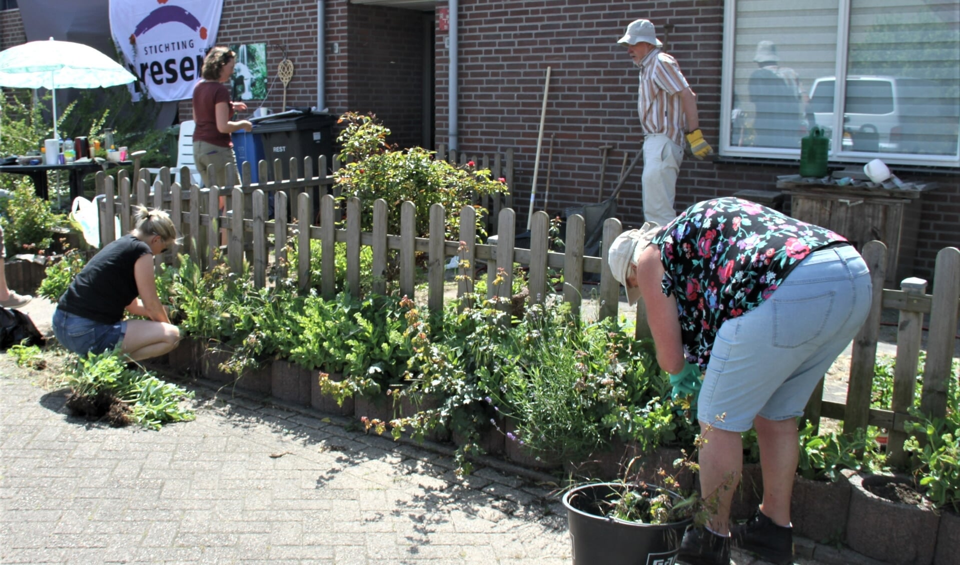 • Vrijwilligers bezig met het verfraaien van één van de drie tuinen.