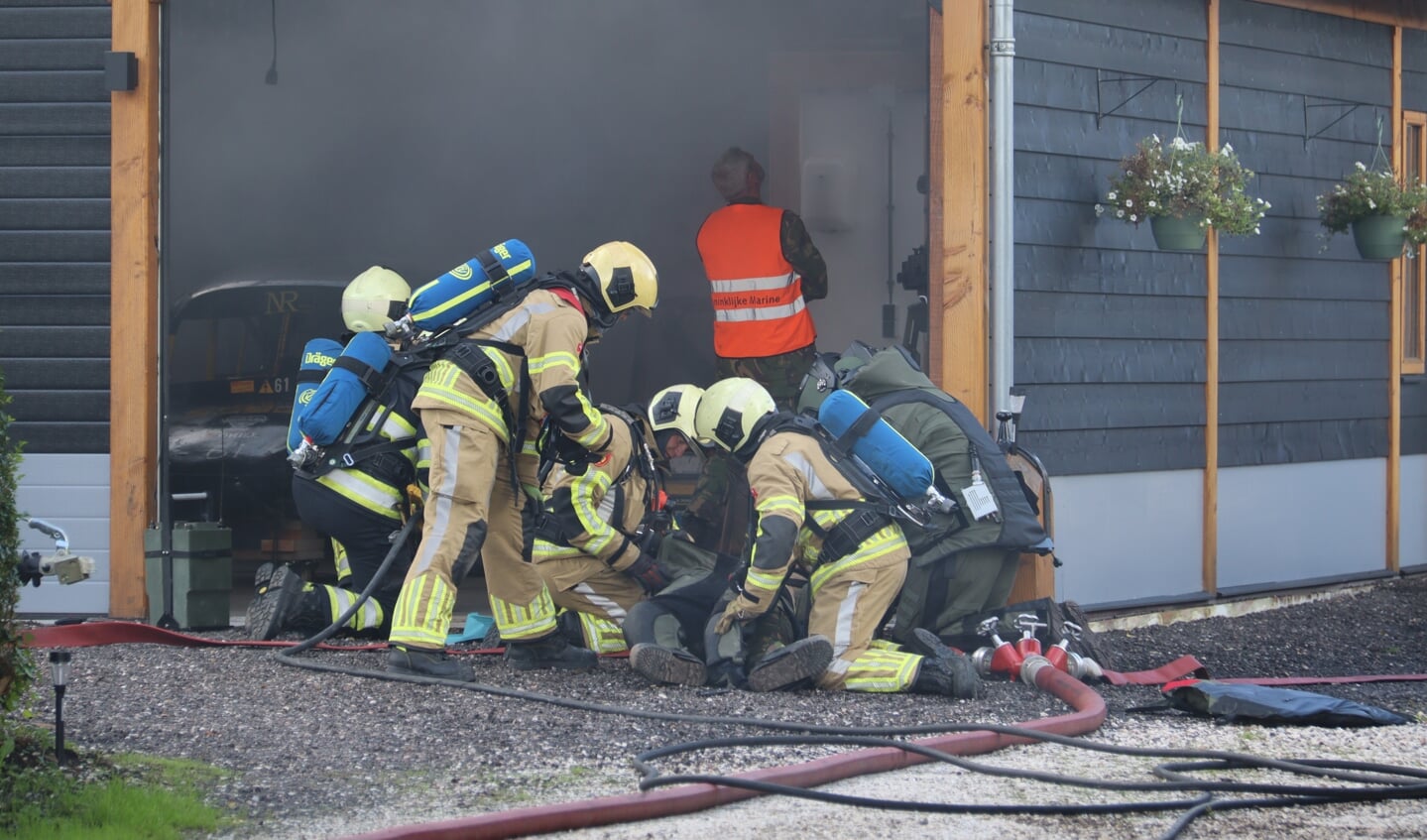 • Brandweermannen bekommeren zich om het 'slachtoffer'. 